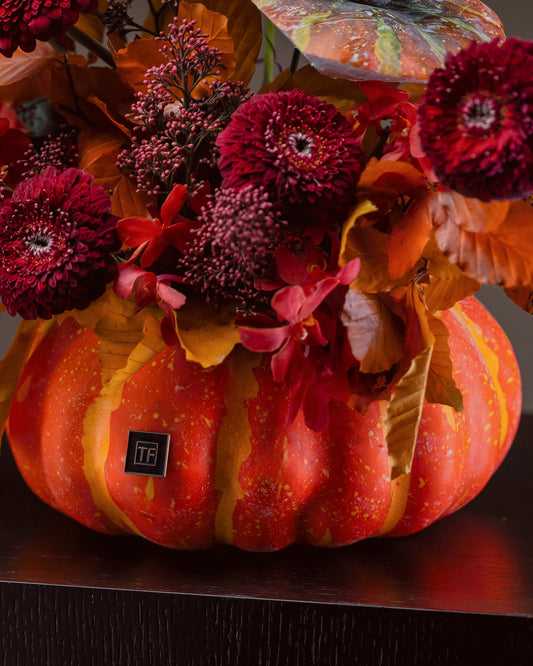 Monster Mash Flower Arrangement featuring burgundy cymbidium orchids and crimson blooms in a ceramic pumpkin centerpiece